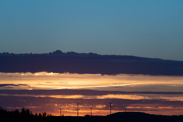 Obraz premium Wind turbines on a background of orange sunset sky