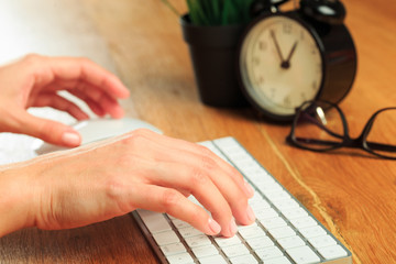 Female hands typing on white wireless modern keyboard  on wooden table   - Image
