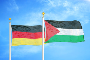 Germany and Palestine two flags on flagpoles and blue cloudy sky