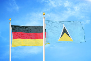 Germany and Saint Lucia two flags on flagpoles and blue cloudy sky