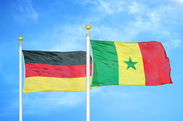 Germany and Senegal two flags on flagpoles and blue cloudy sky
