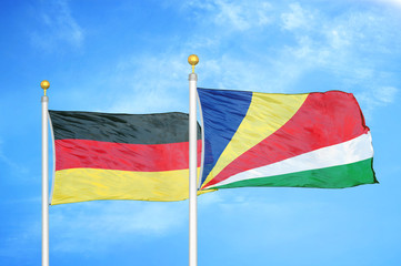Germany and Seychelles two flags on flagpoles and blue cloudy sky