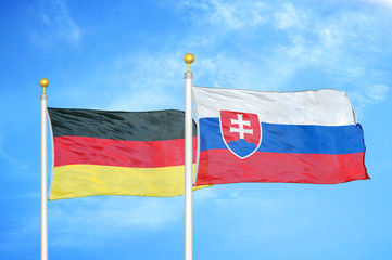 Germany and Slovakia two flags on flagpoles and blue cloudy sky