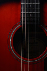 Obraz premium Beautiful background photo of an acoustic guitar close up focused on its strings, frets, and mouth