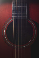 Obraz premium Beautiful background photo of an acoustic guitar close up focused on its strings, frets, and mouth