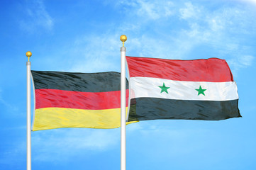 Germany and Syria two flags on flagpoles and blue cloudy sky