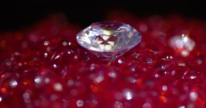 Big shiny real diamond surrounded by a heart shaped red stones spinning CCW close-up
