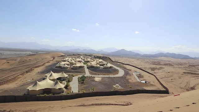 Luxury tent complex in the middle of the dry desert - Oman. Panning shot.