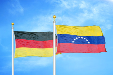 Germany and Venezuela two flags on flagpoles and blue cloudy sky