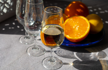 Glasses with cold fino sherry fortified wine and orange in sunlights, andalusian style interior on background