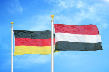 Germany and Yemen two flags on flagpoles and blue cloudy sky