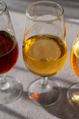 Glasses with cold dry fino and sweet cream sherry fortified wine in sunlights, andalusian style interior on background