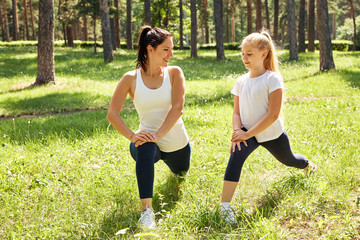 sporty mother and daughter. woman and child training in the park. outdoor sports. healthy sport lifestyle. fitness and yoga