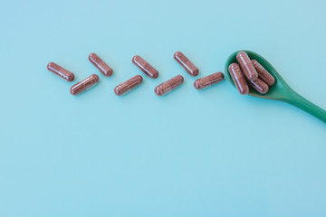 Nutritional supplements. Herbal medicine capsules on a blue background. Vitamin Pill. Top view. Flatlay. Copyspaсe for text.