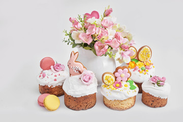 Easter orthodox sweet bread, Easter cake with flowers and gingerbread. Holidays breakfast concept with copy space. Easter greeting card template. Homemade pasques.Easter sweets on white background.