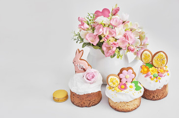 Obraz na płótnie Canvas Easter orthodox sweet bread, Easter cake with flowers and gingerbread. Holidays breakfast concept with copy space. Easter greeting card template. Homemade pasques.Easter sweets on white background.