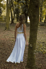 Obraz na płótnie Canvas girl walking in the woods in a white dress