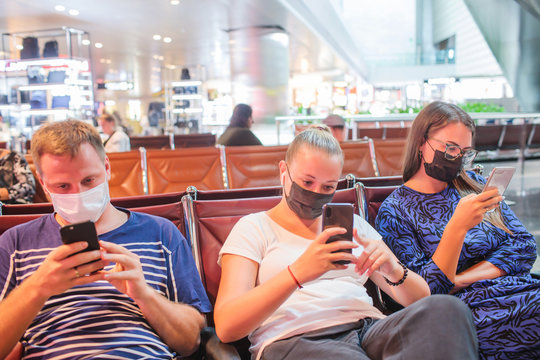 Man In A Medical Mask On His Face Sits At The Airport And Holds A Phone In His Hands. Coronavirus In China. Threat Of Epidemic. Copy Of The Space.