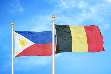 Philippines and Belgium two flags on flagpoles and blue cloudy sky