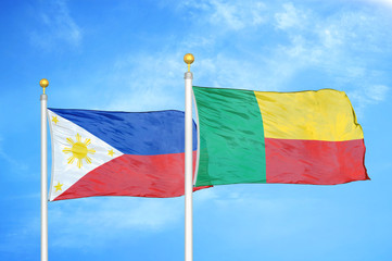 Philippines and Benin two flags on flagpoles and blue cloudy sky