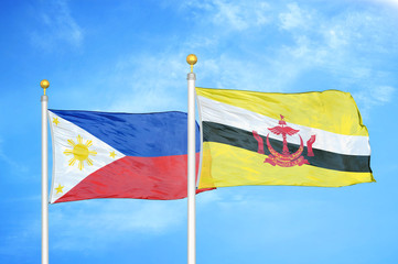 Philippines and Brunei two flags on flagpoles and blue cloudy sky