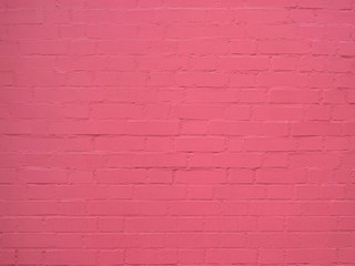 old cracked brick wall painted in pink paint