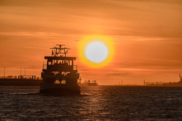Sunset over the Elbe with a ferry  crossing the river