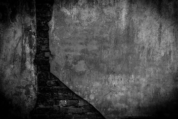 The texture of the crack brick is black. Background of empty cracked brick basement wall. Empty dark black wall.