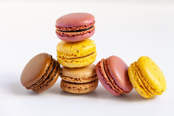 Assortment of delicious traditional french macaroons. Colorful sweet dessert for real gourmands. Lemon, chocolate, caramel, raspberry flavors. White background, copy space, close up, macro, isolated