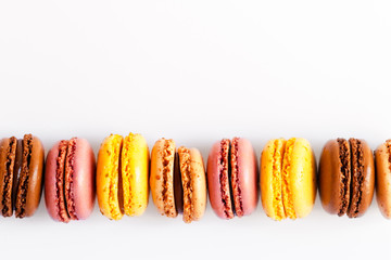 Assortment of delicious traditional french macaroons. Colorful sweet dessert for real gourmands. Lemon, chocolate, caramel, raspberry flavors. White background, copy space, close up, macro, isolated
