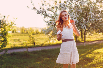 Red-haired model posing on a sunset background.