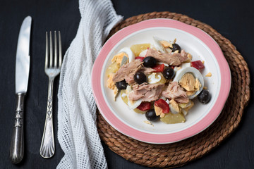 Potato salad with olives, tuna, boiled egg and its dressing. Delicious plate of Spanish food