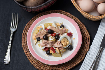 Potato salad with olives, tuna, boiled egg and its dressing. Delicious plate of Spanish food