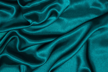 Smooth elegant blue silk or satin luxury cloth texture can be used as abstract background. Crumpled fabric Twisted at the side.