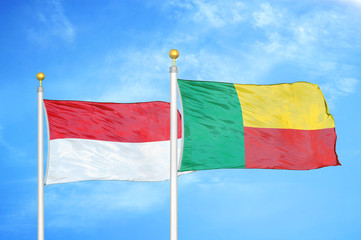 Indonesia and Benin two flags on flagpoles and blue cloudy sky