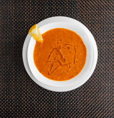 lentil soup with a slice of lemon in a white bowl
