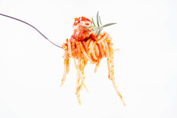 Spaghetti bolognese sprinkled with cheese and decorated with a rosemary twig on a fork on a white background