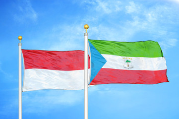 Indonesia and Equatorial Guinea two flags on flagpoles and blue cloudy sky