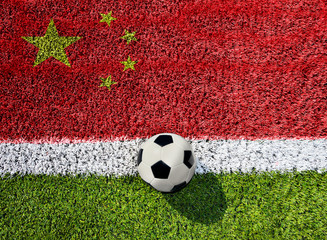 Soccer or football on green grass,on china flag background