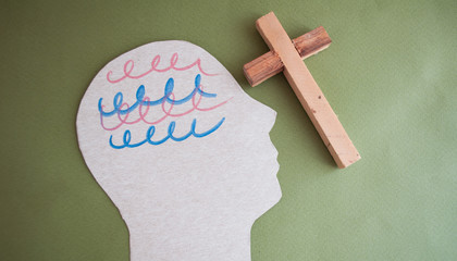 Encephalography brain cutout paper and wooden cross on a green background, awareness of epilepsy,...