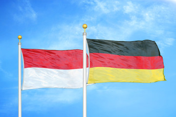 Indonesia and Germany two flags on flagpoles and blue cloudy sky