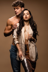 sensual shirtless boyfriend hugging passionate half naked girlfriend in beige jacket on beige
