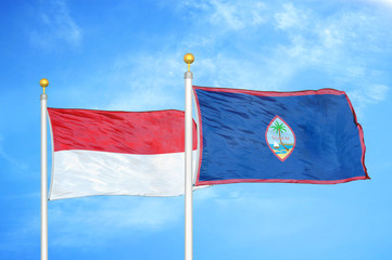 Indonesia and Guam two flags on flagpoles and blue cloudy sky