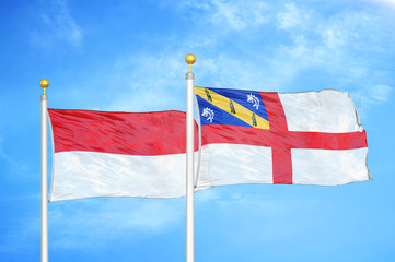 Indonesia and Herm two flags on flagpoles and blue cloudy sky
