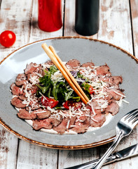 meat carpaccio with vegetables on the table