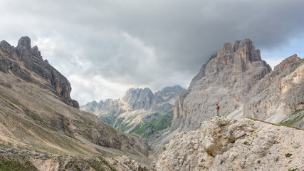 Hiker looking over a valley in the Dolomites Mountains, Italy