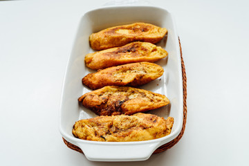 Torrijas, typical Spanish sweet fried toasts of sliced bread soaked in eggs and milk on tray isolated on white background