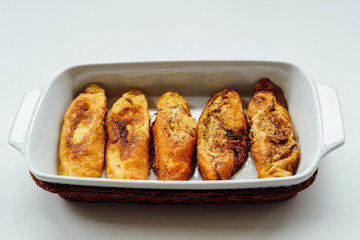 Torrijas, typical Spanish sweet fried toasts of sliced bread soaked in eggs and milk on tray isolated on white background