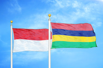 Indonesia and Mauritius two flags on flagpoles and blue cloudy sky