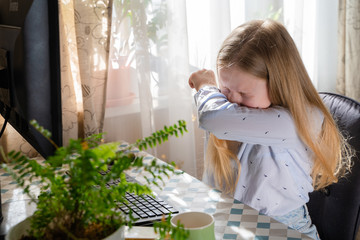 Caucasian young girl sneezing,coughing into her sleeve or elbow to prevent spread Covid-19, virus,sick girl has flu,fever covering nose,mouth with her arm from dusty,allergies,air pollution